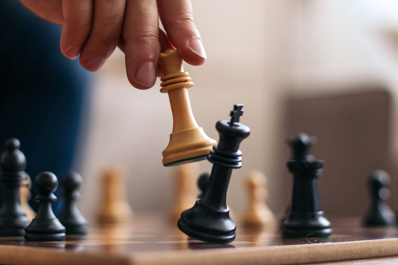 Hand moving a chess piece on the board.