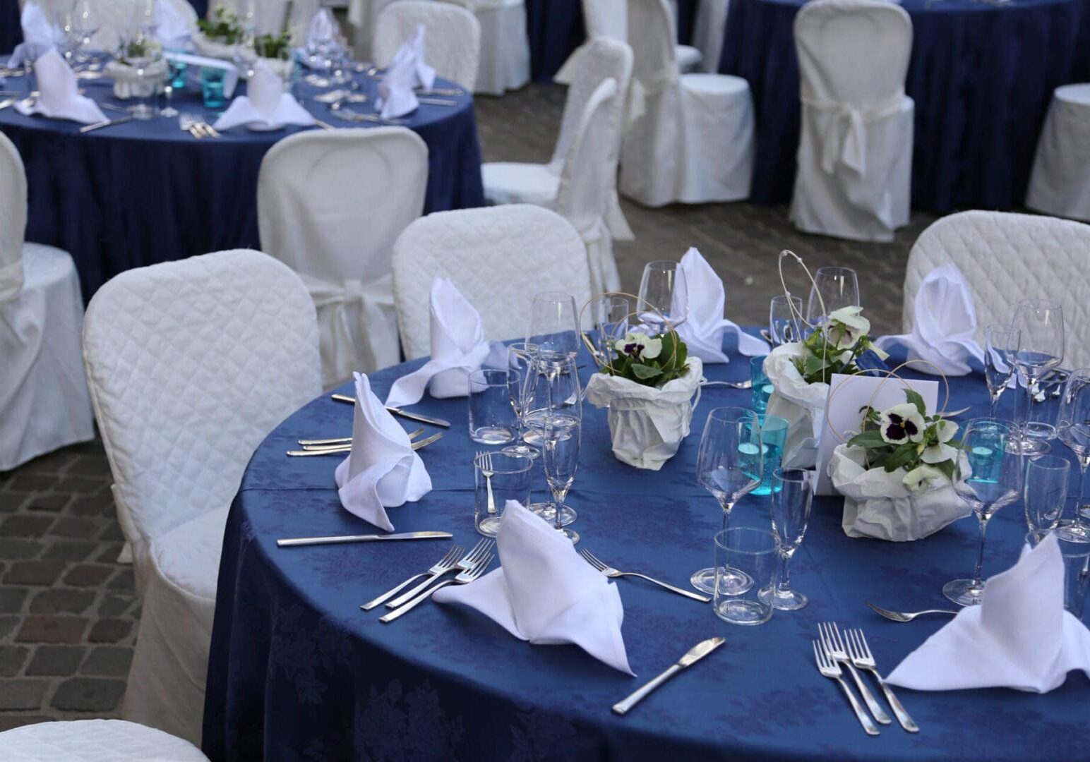 elegant table set before the official lunch with white dish and blue tablecloth